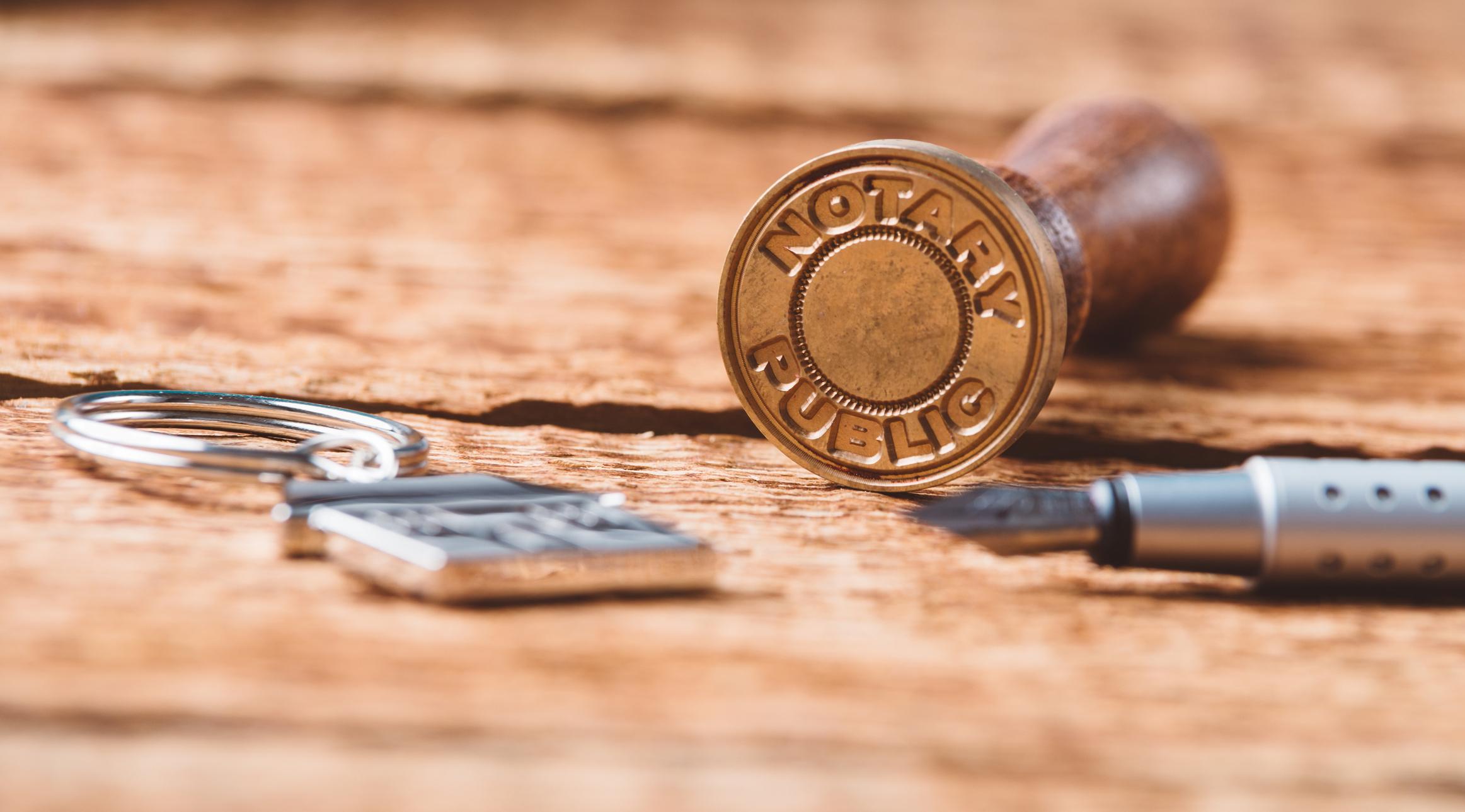 Notary stamp laying on it's side near a pen